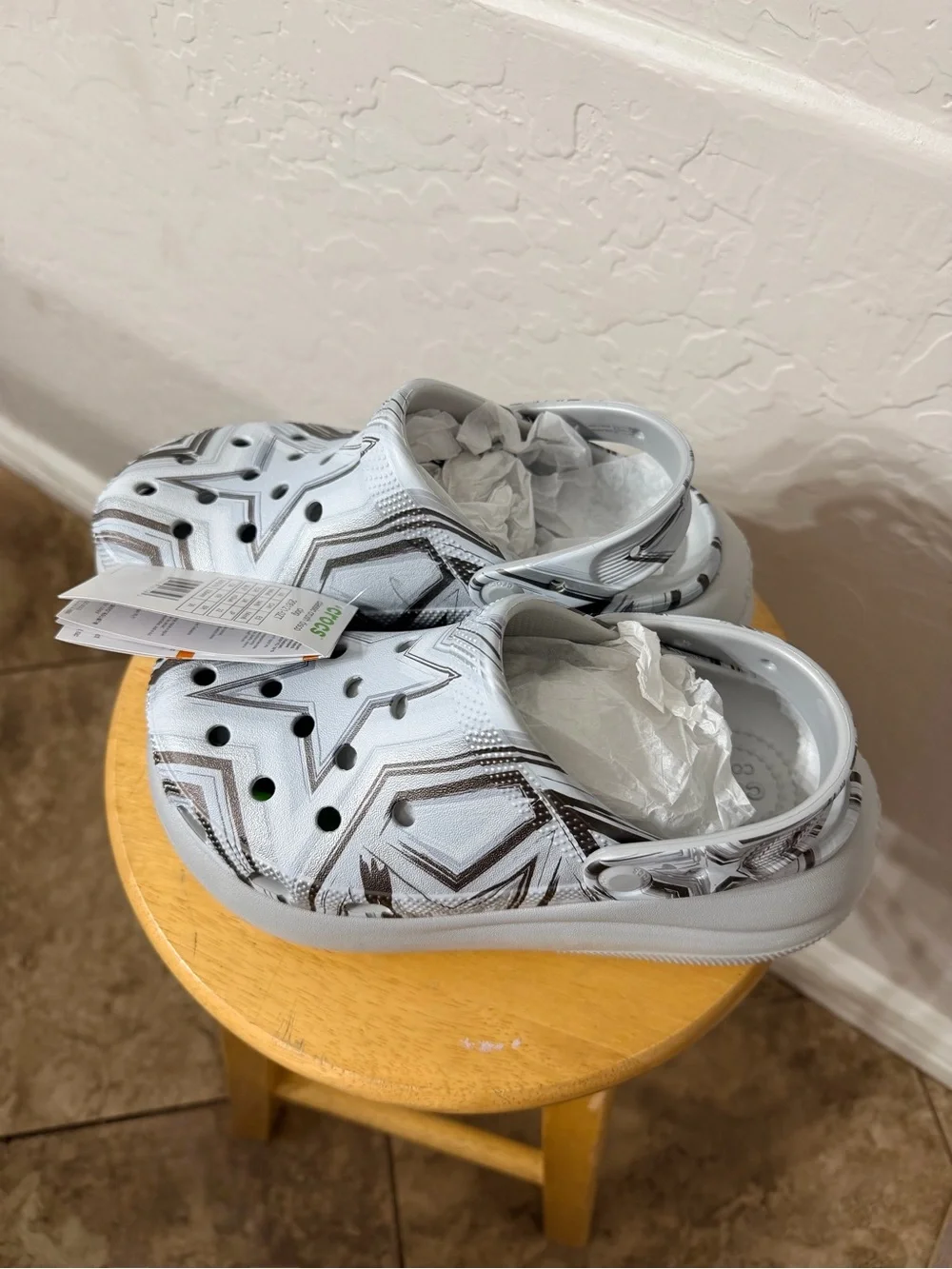 white and gray Crocs with black star and zigzag graphic size W6